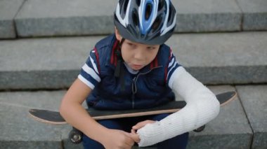 Kırık kol ile sıkılmış beyaz çocuk