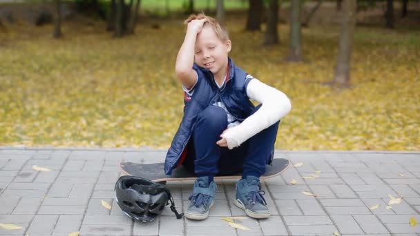 White boy with broken arm put on his helmet — Stock Video