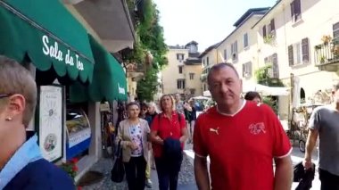 Orta San Giulio, İtalya - 17 Eylül 2017: dar cadde boyunca Orta San Guilio üzerinde yürüyen insanlar,
