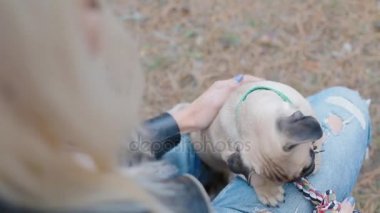 Beyaz kadın açık havada köpek pug ile oynamak