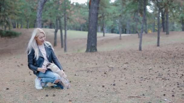 Біла жінка грає з цуценя мопса на відкритому повітрі — стокове відео