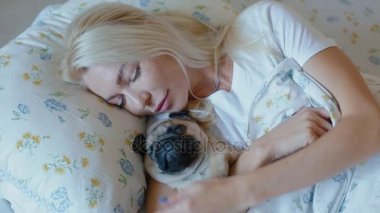 Kadın köpek pug ile yatakta kal