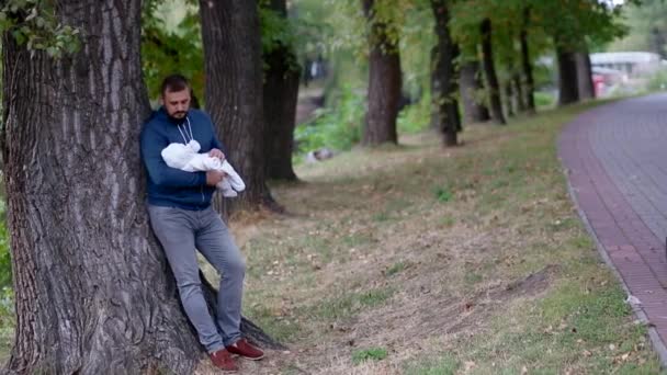 Молодой человек держит свою новорожденную дочь на руках — стоковое видео