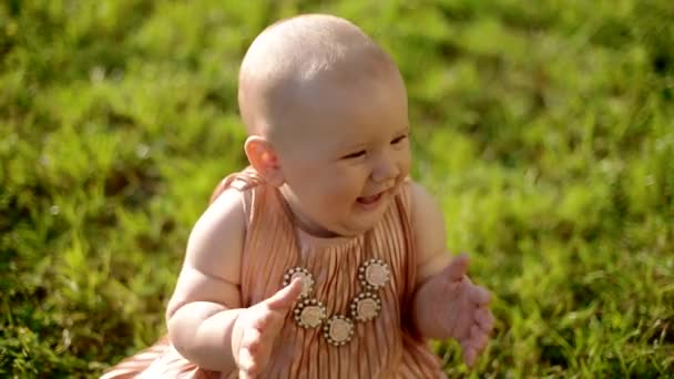 Portret van babymeisje zittend op het gras — Stockvideo