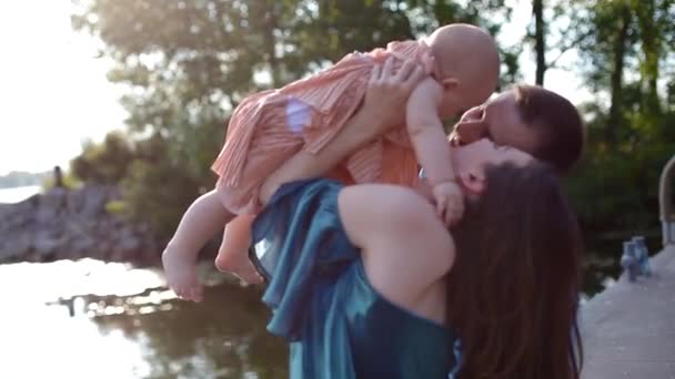 Jeune famille avec petit enfant près de la rivière — Video