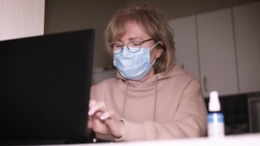 Üst düzey kadın evde çalışırken ellerini sterilize ediyor.