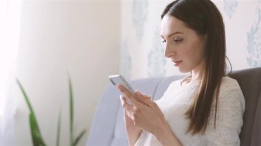 Koltukta oturan cep telefonu kullanan bir kadın.