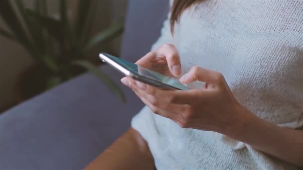 Mulher usando telefone celular sentado no sofá — Vídeo de Stock