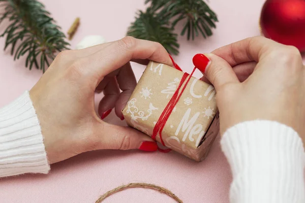 Ruční dárkové balení a zdobení dárku zabaleného ve slavnostním papíru s nápisem Vánoce — Stock fotografie