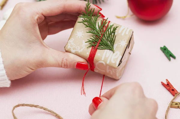 Ruční dárkové balení a zdobení dárku zabaleného ve slavnostním papíru s nápisem Vánoce — Stock fotografie
