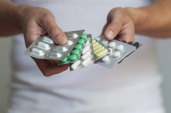 Paketteki haplar hafif arka plandaki bir adamın elinde.