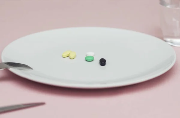 Pillen auf einem Teller, Pillen ersetzen Nahrung, schwarze Tablette, auf rosa Hintergrund — Stockfoto