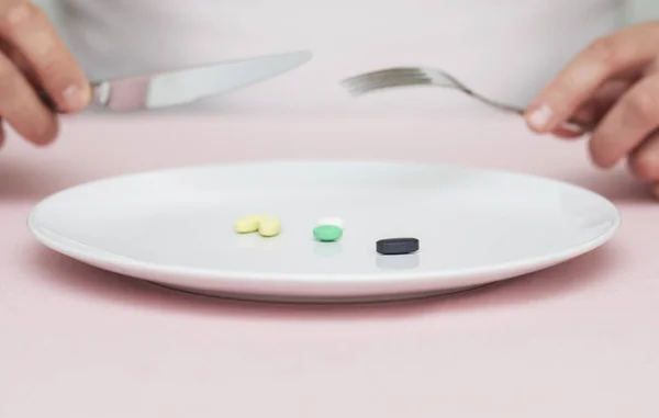 pills on a plate, man eats pills from a plate, food supplements