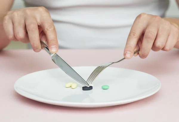 pills on a plate, man eats pills from a plate, food supplements