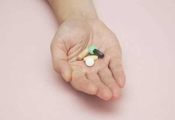 Bir insanın avucunda haplar, haplar, ilaçlar, ilaçlar...