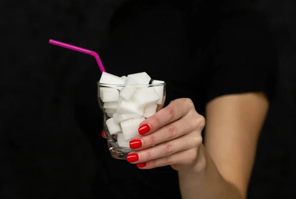 Kız elinde bir bardak beyaz şeker tutuyor.,