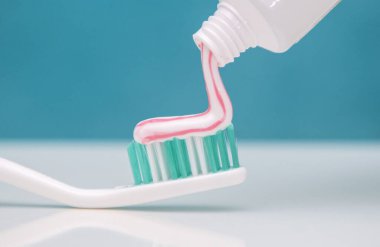 Diş bakımı ve oral bakım ürünleri açık yeşil arka planda yakın plan