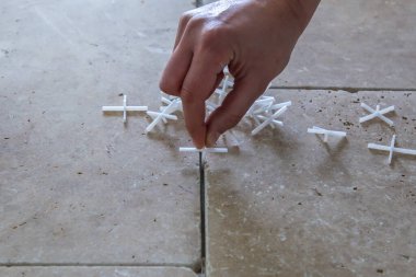 taş kiremitlerin arka planında, döşemek için beyaz plastik haçlar