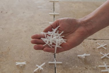 taş kiremitlerin arka planında, döşemek için beyaz plastik haçlar