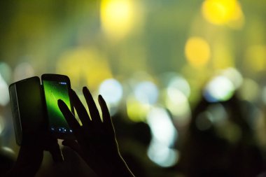 Konserde kalabalık ve bulanık sahne ışıkları .