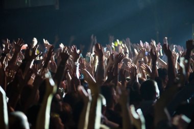 Konserde kalabalık ve bulanık sahne ışıkları .