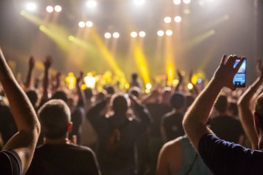 Konserde kalabalık ve bulanık sahne ışıkları .