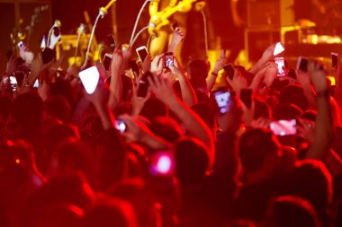 Konserde kalabalık ve bulanık sahne ışıkları .