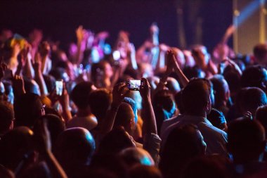Konserde kalabalık ve bulanık sahne ışıkları .