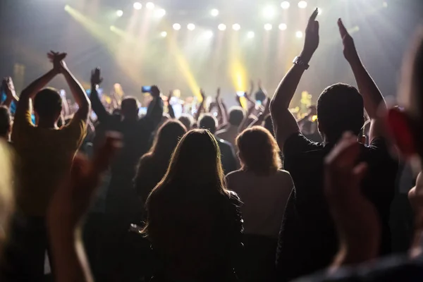 Crowd at concert and blurred stage lights .