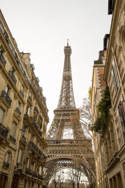 Paris 'te bulutlu bir günde Paris Eyfel Kulesi manzaralı küçük bir cadde..