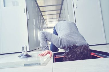 Genç adam bir şey zemin ambarda sabitleme. Veri Merkezi. Sunucuları