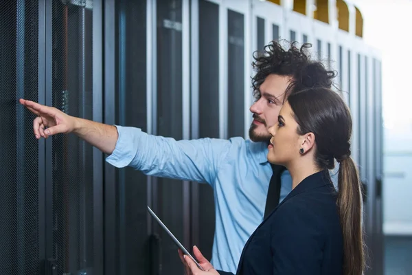 two young technicians working at a data center on server maintenance