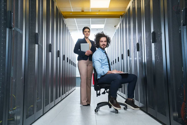 two young technicians working at a data center on server maintenance