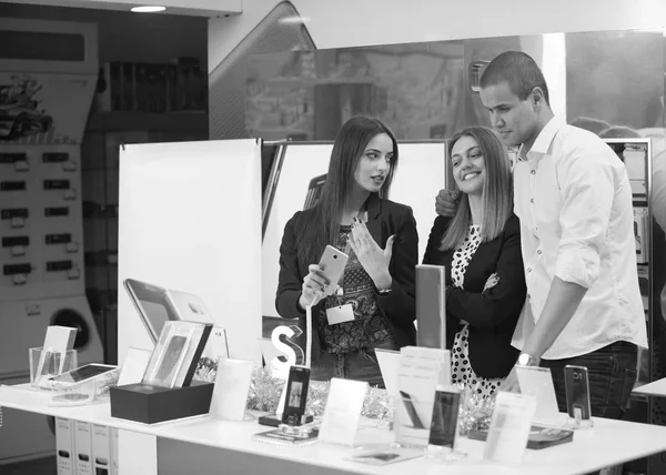 Young couple with a consultant in consumer electronics store