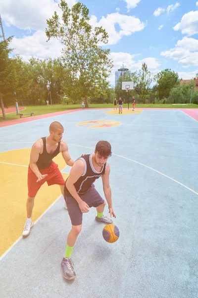 Couple of guys playing basketball outside