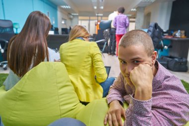 Başlangıç grup içinde modern bir ofis toplantısı bir dizüstü bilgisayar ile yaratıcı insan portresi. Konuşma alanı coworking yeni proje üzerinde rahat iş adamları