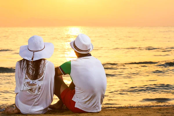 オレンジ色の夕日背景 幸せの中に海の日の出を楽しんで手を繋いでいるカップル旅行休暇休暇のビーチの上に立って愛のロマンチックなカップルの新婚旅行します — ストック写真