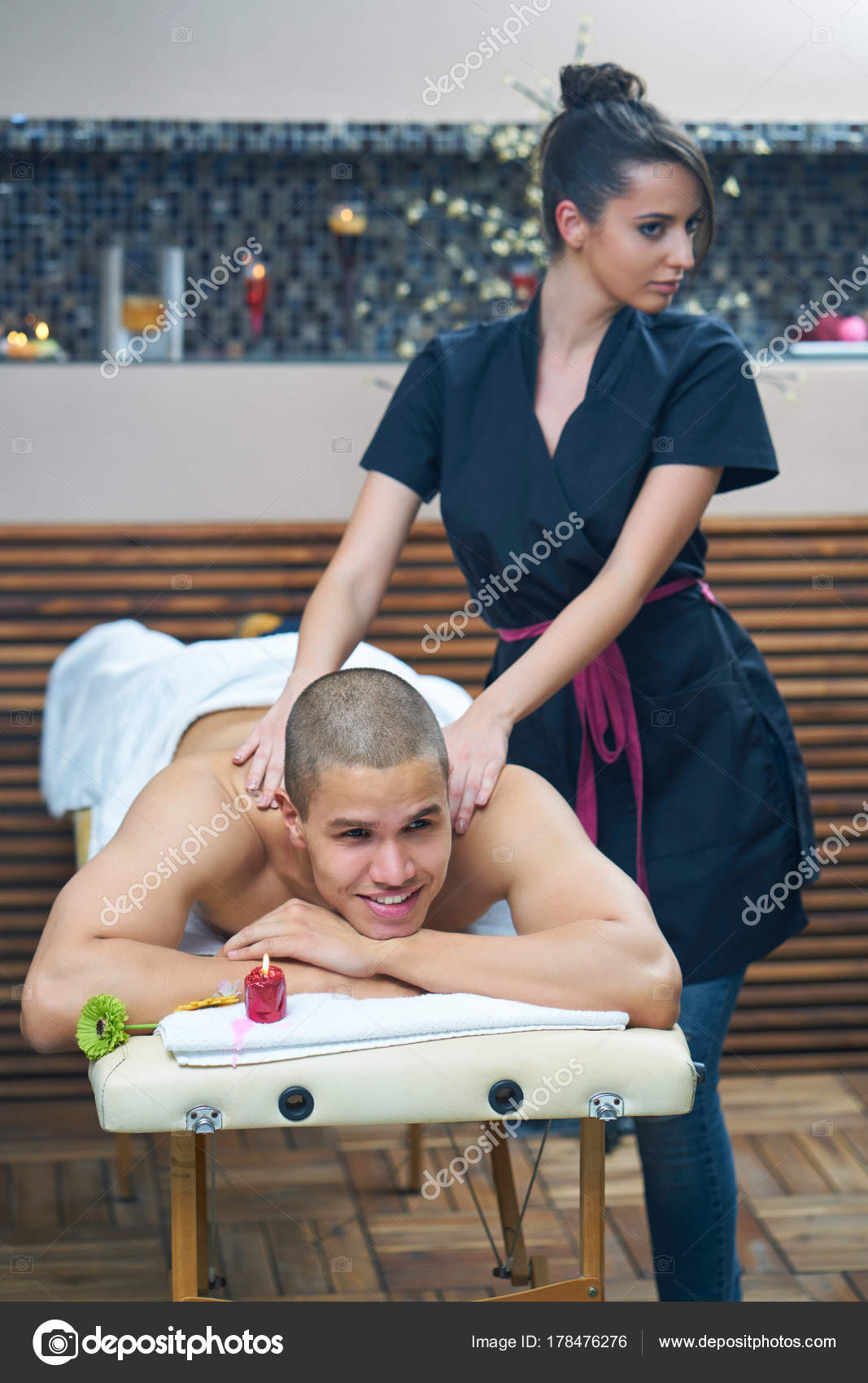 Sports massage. Massage therapist massaging shoulders of a male athlete,  working with Trapezius muscle. Toned image. Masseur doing massage on man  body in the spa salon. Beauty treatment concept. Stock Photo