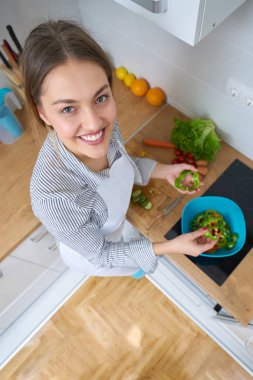 Genç kadın mutfakta taze sebze sepeti