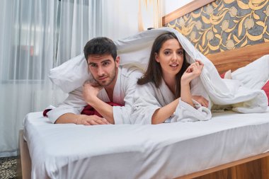 concept d'hôtel, voyages, relations et le bonheur - heureux couple au lit