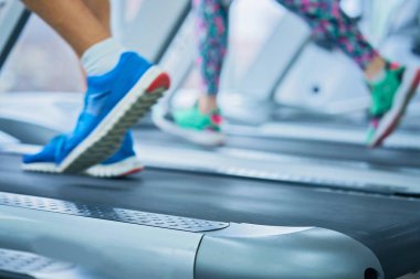 Spor salonunda treadmill çalışan spor ayakkabı kadın kas ayak