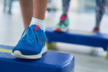 Atletik kadın eğitmen bir modern fitness merkezi insanlar grubuna Stepper ile aerobik sınıf yapıyor. Spor ve sağlık kavramı.