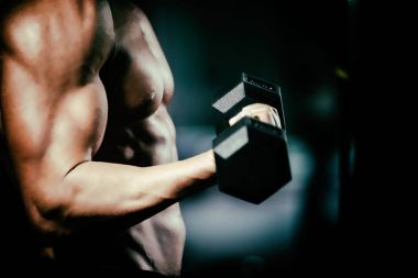 Yakışıklı ve güçlü bir adam güzel vücut salonunda egzersizleri yapıyor ile