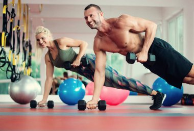 Güzel genç spor insanların spor salonunda dumbbells ile çalışıyoruz