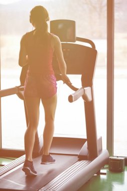 Kız koşu bandı üzerinde çalışır. Etkin kız spor salonunda koşu bandı üzerinde çalışır. Atlet kardiyo aktivite koşu bandı.