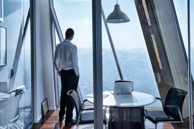 Genç işadamı ofiste dizüstü bilgisayarla çalışıyor.