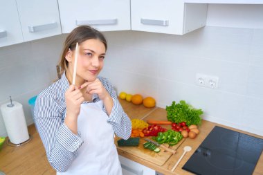 Genç kadın mutfakta taze sebze sepeti
