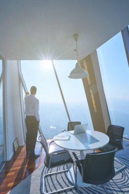 Genç işadamı ofiste dizüstü bilgisayarla çalışıyor.