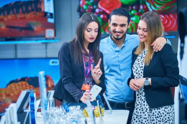 tüketici elektroniği genç bir çift satın almak en son dizüstü bilgisayar, televizyon ve fotoğraf kamera seyir saklamak