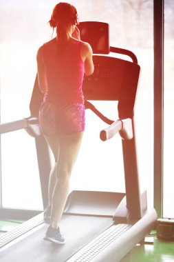 Kız koşu bandı üzerinde çalışır. Etkin kız spor salonunda koşu bandı üzerinde çalışır. Atlet kardiyo aktivite koşu bandı.